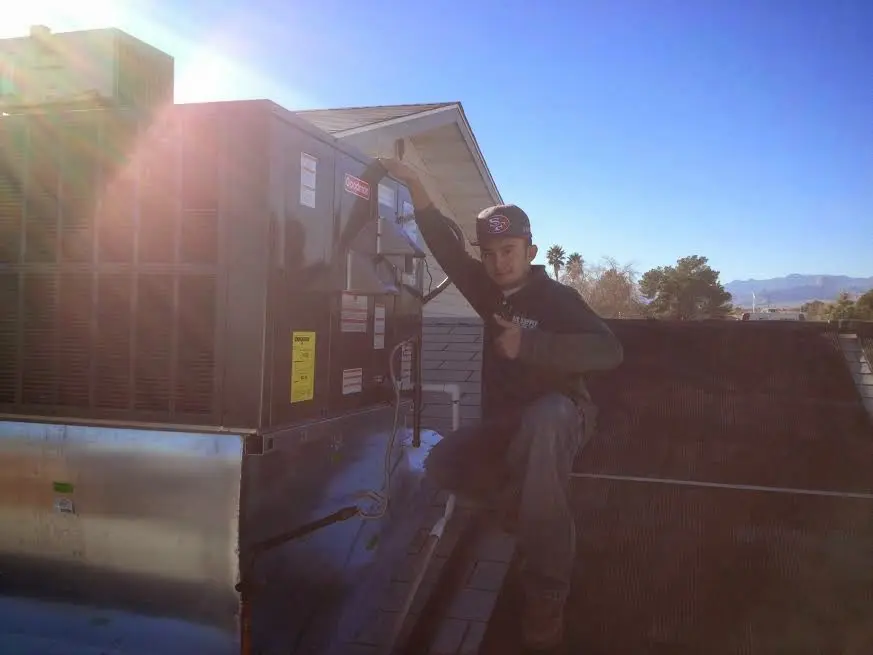 HVAC technician performing AC Tune-Up on a rooftop unit in Taylor